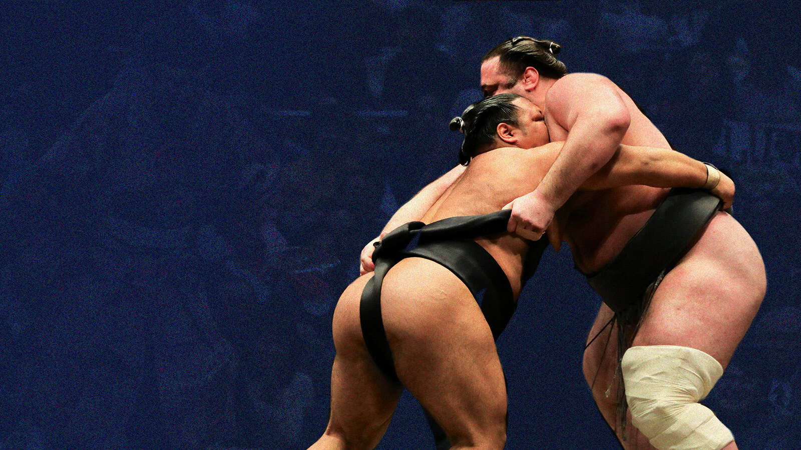 Two sumo wrestlers grappling during a match.