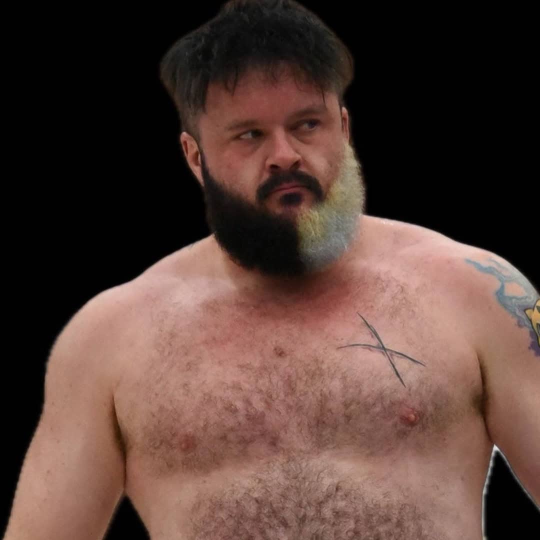 Sumo wrestler with a beard and tattoos during a match.