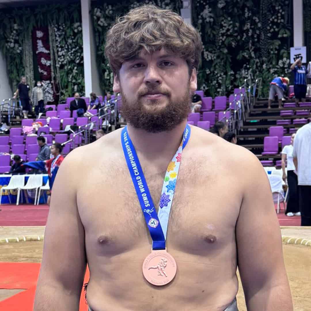 Sumo athlete with bronze medal at competition.