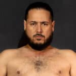 Close-up of a sumo wrestler with long hair and beard.