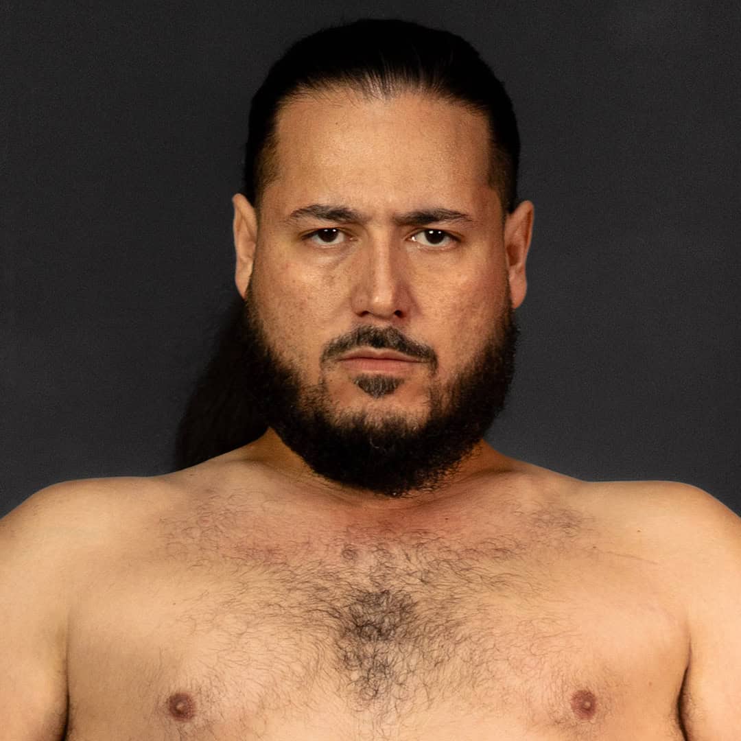 Close-up of a sumo wrestler with long hair and beard.