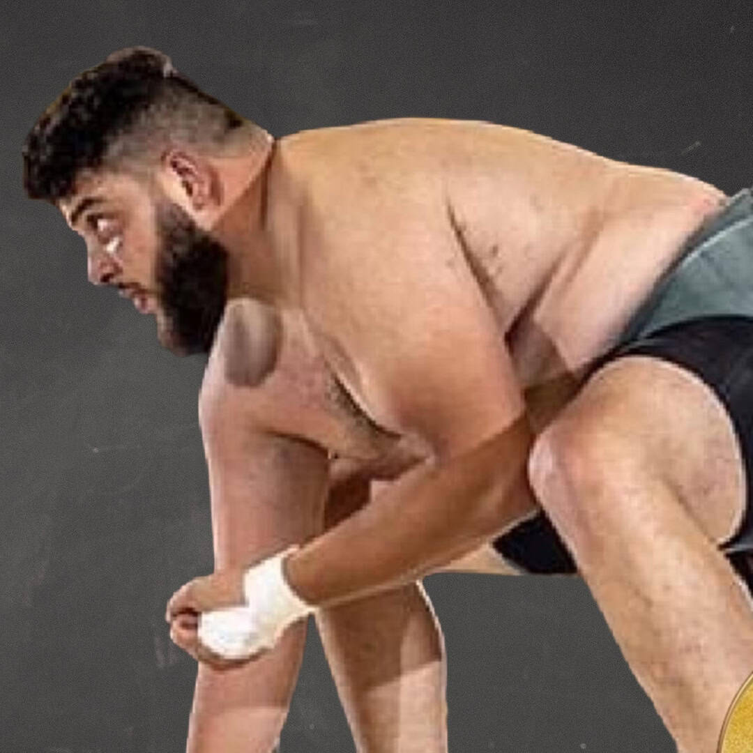 Sumo wrestler preparing for match in stance.