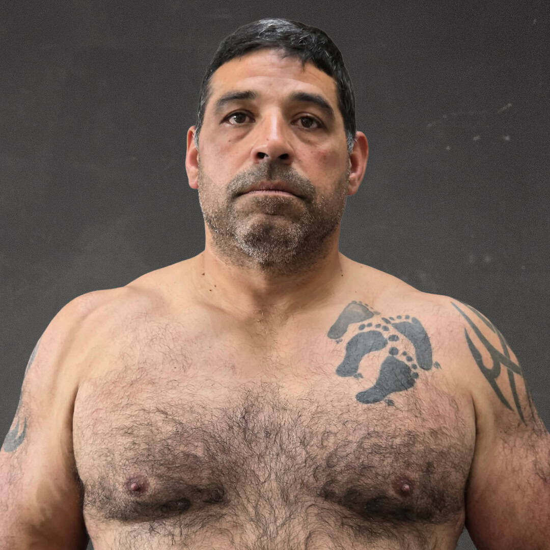 Sumo wrestler with tattoos and short black hair.